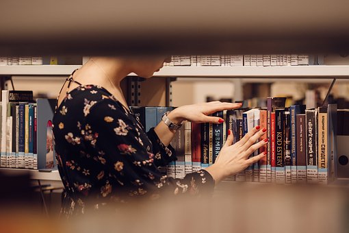 mujer en una biblioteca buscando un libro