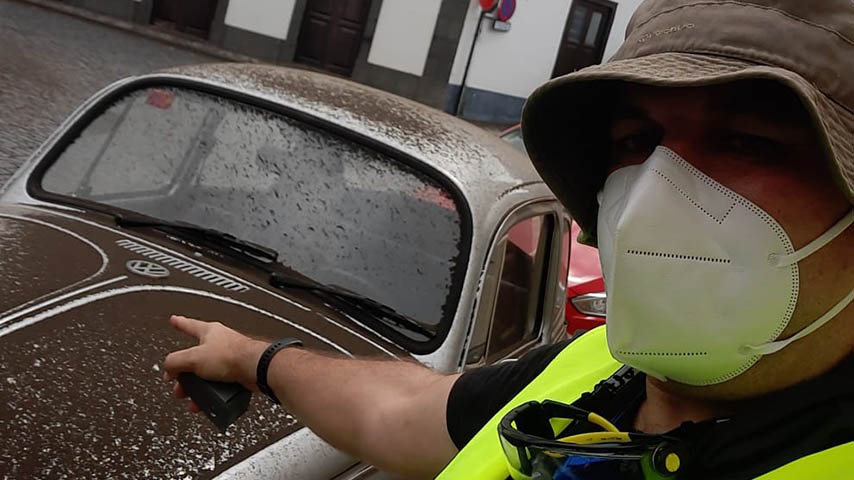 An investigator points the ash accumulated in a car