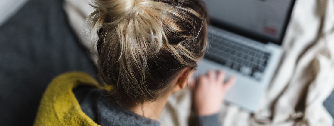 A GIRL TYPES ON A LAPTOP
